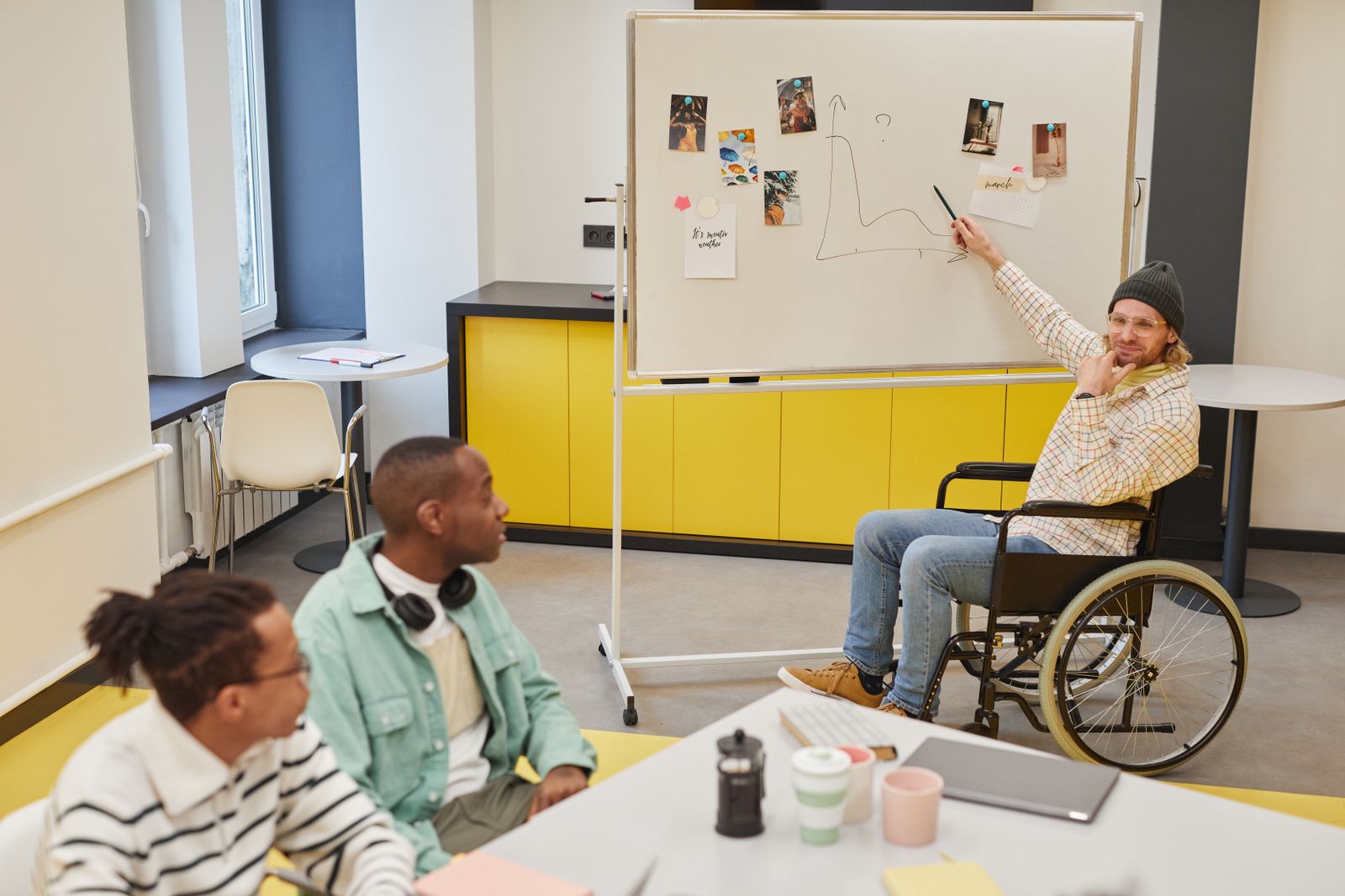 Facilitador apresenta gráfico em um quadro para equipe em atividade de aprendizagem, tema de palestrantes de neurociência